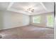 Spacious bedroom with tray ceiling, carpet, large window and backyard access at 9109 Loch Glen Way, Charlotte, NC 28278