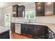 Modern kitchen showcasing dark wood cabinets, granite countertops, and stainless steel appliances at 9109 Loch Glen Way, Charlotte, NC 28278