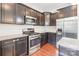 Bright kitchen features stainless steel appliances, granite countertops, subway tile backsplash and dark wood cabinets at 9109 Loch Glen Way, Charlotte, NC 28278