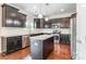 Modern kitchen featuring dark cabinetry, stainless steel appliances, a center island, and hardwood floors at 9109 Loch Glen Way, Charlotte, NC 28278