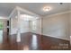 Bright, open-concept living room featuring hardwood floors, crown molding, and decorative pillars at 9109 Loch Glen Way, Charlotte, NC 28278