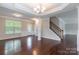 Bright living room showcasing hardwood floors, a staircase with iron spindles, and recessed lighting at 9109 Loch Glen Way, Charlotte, NC 28278