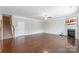 Large living room with hardwood floors, a fireplace, and access to a staircase, blending comfort and style at 9109 Loch Glen Way, Charlotte, NC 28278
