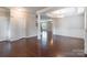 Bright, open-concept living room featuring hardwood floors, crown molding, and decorative pillars at 9109 Loch Glen Way, Charlotte, NC 28278