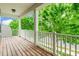 Covered porch with wood floors and a white railing, surrounded by lush greenery at 9109 Loch Glen Way, Charlotte, NC 28278