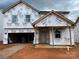 New construction home featuring Tyvek home wrap and a two-car garage in a modern, unfinished style at 918 Windy Oak Ct, Indian Trail, NC 28079