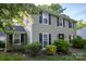 Well-maintained home with black shutters, complemented by landscaped bushes and lawn at 9801 Kent Village Dr, Charlotte, NC 28269