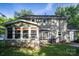 Rear of home showing the enclosed sunroom and a well-manicured yard at 9801 Kent Village Dr, Charlotte, NC 28269