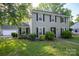 Charming two-story home with a manicured front yard and lush landscaping at 9801 Kent Village Dr, Charlotte, NC 28269