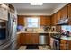 Functional kitchen with stainless steel appliances and wood cabinets at 9801 Kent Village Dr, Charlotte, NC 28269