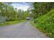 A long driveway leads to a detached garage surrounded by lush greenery and flowering plants at 1009 Catawba Valley Se Blvd, Hickory, NC 28602