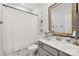 Cozy bathroom featuring a shower with striped curtain, modern art, and a stylish wood-framed mirror above the sink at 104 Trellis Ln, Troutman, NC 28166