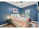Cozy bedroom with blue walls, plush bedding, a ceiling fan, and a window view at 104 Trellis Ln, Troutman, NC 28166