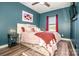 Stylish bedroom boasts a cozy bed with an eclectic rug, teal walls, and warm lighting, offering a comfortable retreat at 104 Trellis Ln, Troutman, NC 28166
