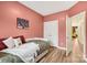Cozy bedroom with a daybed, hardwood floors, salmon colored walls, and an open doorway at 104 Trellis Ln, Troutman, NC 28166