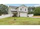 Inviting two-story home with a well-kept lawn, brick accents, and a two-car garage at 104 Trellis Ln, Troutman, NC 28166