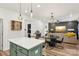 Charming kitchen with a green island, modern lighting and an open-concept view to the living and dining area at 104 Trellis Ln, Troutman, NC 28166
