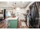 Bright kitchen with white cabinets, stainless steel appliances, a green island, and hardwood floors at 104 Trellis Ln, Troutman, NC 28166