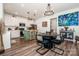 Open kitchen with white cabinets, a green island, a round dining table, and an eye-catching peacock art piece at 104 Trellis Ln, Troutman, NC 28166
