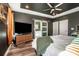 An elegant main bedroom boasts a modern TV, tray ceiling, and sliding barn door to the primary bathroom at 104 Trellis Ln, Troutman, NC 28166