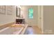 Bathroom featuring large soaking tub with decorative architectural features and window at 10501 Stonemede Ln, Matthews, NC 28105