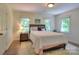 Bedroom with hardwood floors, two windows, and a comfortable bed with decorative pillows at 10501 Stonemede Ln, Matthews, NC 28105