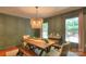 Well-lit dining room with a rustic wooden table, bench seating, and decorative light fixture at 10501 Stonemede Ln, Matthews, NC 28105