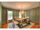 Elegant dining room with wainscoting, a rustic table with bench seating, and stylish lighting at 10501 Stonemede Ln, Matthews, NC 28105