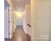 Inviting hallway with wood floors, neutral walls, and overhead lighting leading to various rooms at 10501 Stonemede Ln, Matthews, NC 28105