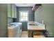 Practical laundry room with modern washer, dryer, sink, and ample counter space at 10501 Stonemede Ln, Matthews, NC 28105
