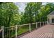 Spacious back deck with brown planking overlooking a lush, green, tree-lined backyard at 110 Cramer Mountain Woods None, Cramerton, NC 28032