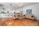 Open-concept living area with hardwood floors and a view of the bright, eat-in kitchen at 110 Cramer Mountain Woods None, Cramerton, NC 28032