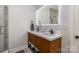 Elegant bathroom features a dual vanity with wood cabinetry and a modern, lighted mirror at 14807 Middlesborough Dr, Matthews, NC 28104