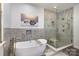Modern bathroom showcasing a soaking tub and glass-enclosed shower with stylish tile work at 14807 Middlesborough Dr, Matthews, NC 28104