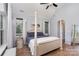 Bright bedroom featuring a four-poster bed, wood floors, and natural light at 14807 Middlesborough Dr, Matthews, NC 28104