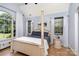 Bright bedroom featuring a four-poster bed, wood floors, and large windows offering natural light at 14807 Middlesborough Dr, Matthews, NC 28104