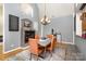 Elegant dining room with a fireplace, modern chandelier, and seating for four at 14807 Middlesborough Dr, Matthews, NC 28104