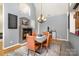 Dining area with a fireplace, chandelier, and seating for four, creating a cozy and inviting atmosphere at 14807 Middlesborough Dr, Matthews, NC 28104