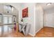 Hallway with hardwood floors, modern console table, and eye-catching wall art at 14807 Middlesborough Dr, Matthews, NC 28104