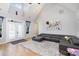 Bright living room with vaulted ceilings, modern sofa, and hardwood floors at 14807 Middlesborough Dr, Matthews, NC 28104