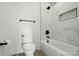 Modern bathroom with a bathtub and shower featuring white marble tile and black hardware at 149 Shady Cove Rd, Troutman, NC 28166