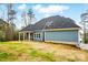 Rear view of a blue house with a covered patio and a wide open yard at 149 Shady Cove Rd, Troutman, NC 28166