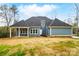 Rear view of a blue house with a covered patio and large yard at 149 Shady Cove Rd, Troutman, NC 28166