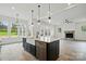 Bright eat-in kitchen with black island and sink has stone fireplace in the adjacent living area at 149 Shady Cove Rd, Troutman, NC 28166