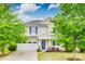 Charming two-story home featuring a well-manicured lawn, blue door, and attached two-car garage at 1507 Arcadia Bluff Dr, York, SC 29745