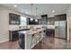 Modern kitchen featuring black cabinets, stainless steel appliances, granite countertops, and a large island at 1507 Arcadia Bluff Dr, York, SC 29745