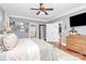 Spacious bedroom features a ceiling fan, and a tv over a wooden cabinet at 162 Kenway Loop, Mooresville, NC 28117