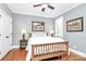 This cozy bedroom offers hardwood floors, a wooden bed frame, fresh gray paint, and bright, natural light at 162 Kenway Loop, Mooresville, NC 28117