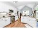 Bright kitchen features white cabinets, stainless steel appliances, granite countertops, and hardwood floors at 162 Kenway Loop, Mooresville, NC 28117