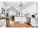 Bright kitchen features white cabinets, stainless steel appliances, granite countertops, and hardwood floors at 162 Kenway Loop, Mooresville, NC 28117
